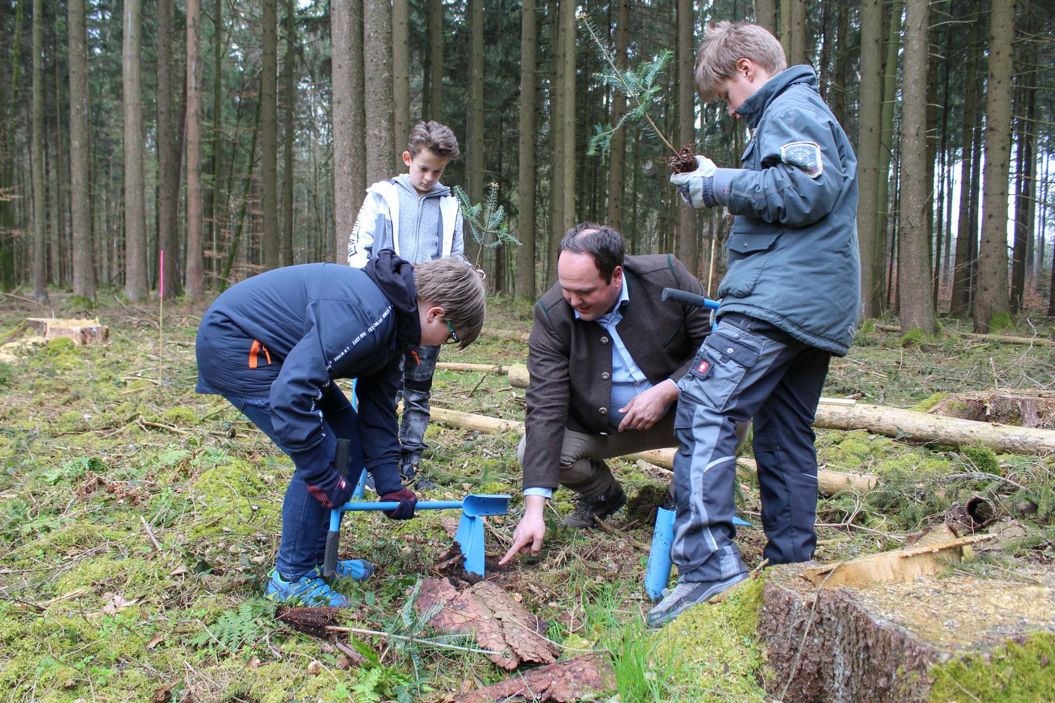 Christian Kaul, Sprecher der Vertreter der Bayerischen Forstwirtschaft (VBF) zeigt Schülern die Pflanztechnik. Foto C. Josten, ZWFH Christian Kaul, Sprecher der Vertreter der Bayerischen Forstwirtschaft (VBF) zeigt den Schülern die Pflanztechnik. Foto C. Josten, ZWFH
