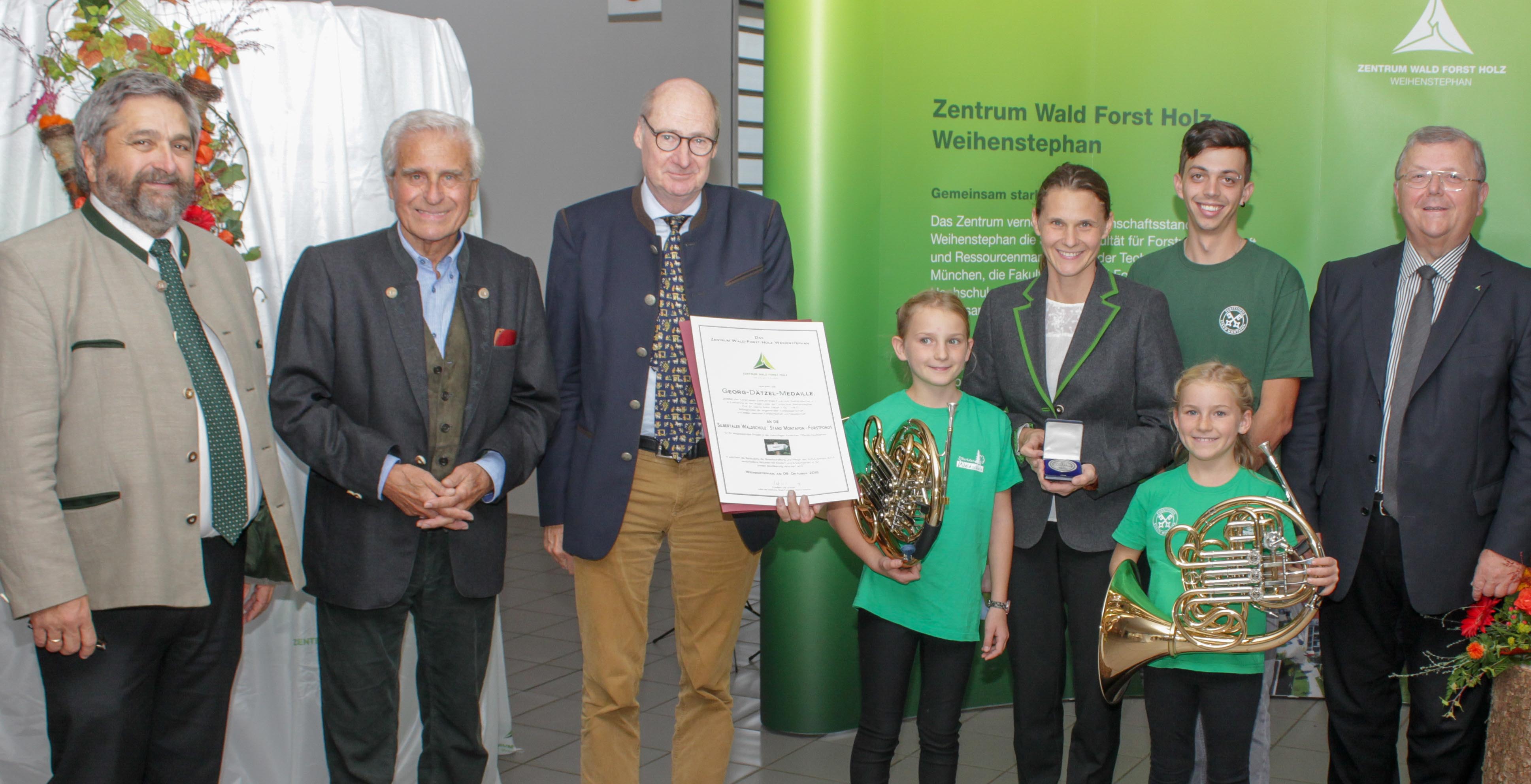 Das Zentrum wird 15 und verleiht die Georg-Dätzel-Medaille and die Silbertaler Waldschule: v.l. H. Förster, Geschäftsführer ZWFH, Festredner Professor G. Wegener, Professor R. Mosandl, 1. Vorsitzender des Fördervereins ZWFH e.V. mit Urkunde, DI S. Ackerl, Leiterin der Silbertaler Waldschule mit den Töchtern Johanna und Daniela, A. Fijatkowski, Förster und Waldpädagoge an der Silbertaler Waldschule und O. Schmidt, Präsident der LWF und Leiter des ZWFH Das Zentrum wird 15 und verleiht die Georg-Dätzel-Medaille and die Silbertaler Waldschule: v.l. H. Förster, Geschäftsführer ZWFH, Festredner Professor G. Wegener, Professor R. Mosandl, 1. Vorsitzender des Fördervereins ZWFH e.V. mit Urkunde, DI S. Ackerl, Leiterin der Silbertaler Waldschule mit den Töchtern Johanna und Daniela, A. Fijatkowski, Förster und Waldpädagoge an der Silbertaler Waldschule und O. Schmidt, Präsident der LWF und Leiter des ZWFH